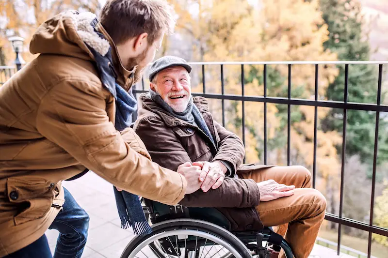 Glücklicher Vater im Rollstuhl mit seinem Sohn
