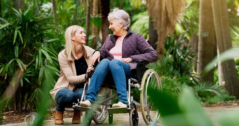 Mutter im Rollstuhl mit Tochter im Park