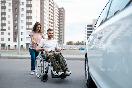 Junges Paar – Rollstuhlfahrer vor der Fahrt zur Arbeit